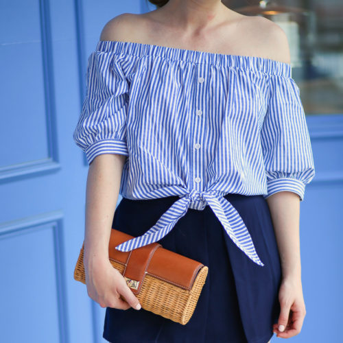 A striped off-the-shoulder top from Tuckernuck paired with a wicker clutch from J.McLaughlin
