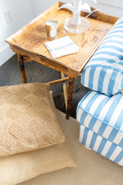 design darling nantucket living room with rattan end tables striped sofas and raffia floor pillows